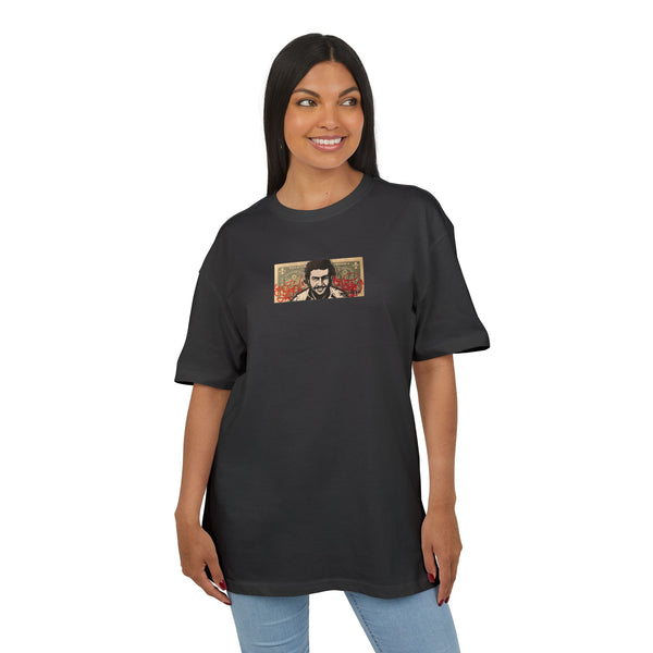 Woman wearing a black t-shirt with a small graphic dollar desing of pablo escobar on the chest against a white background, front